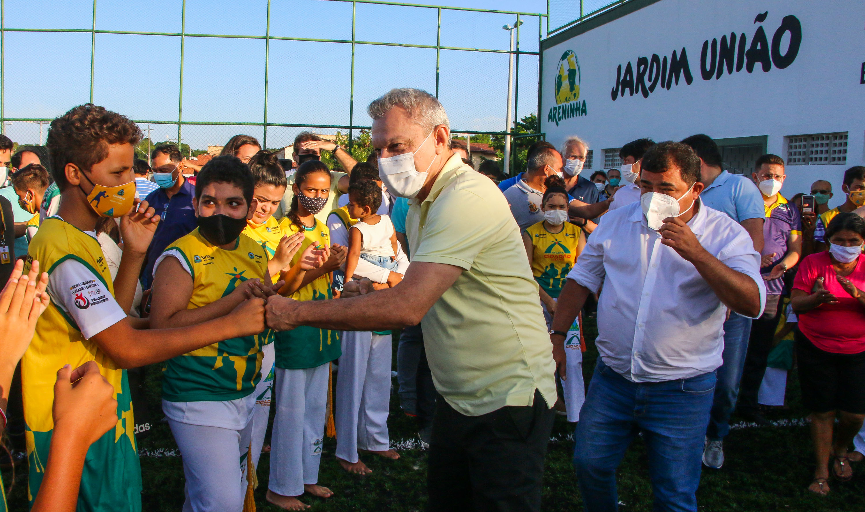 Sarto cumprimenta grupo de crianças na entrada da Areninha